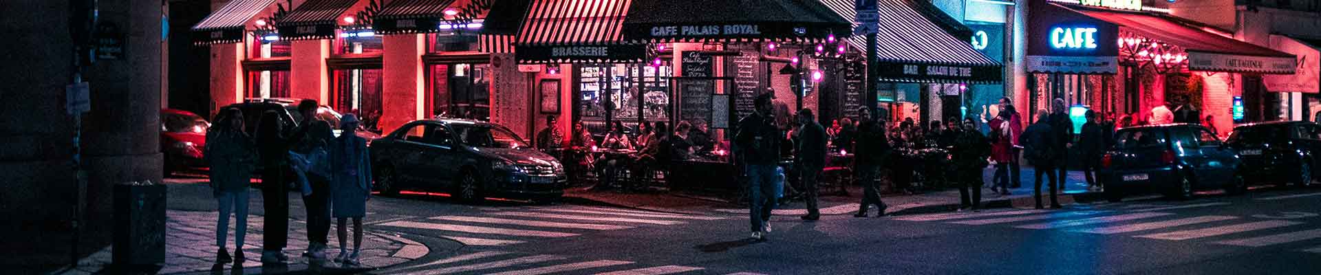 14 question design web local - Paris la nuit, un bar près du carrefour, des personnes traversent la rue
